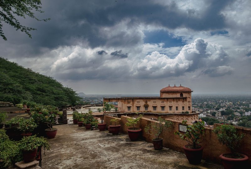 Captivating view of Neemrana Fort-Palace in Rajasthan under dramatic clouds.