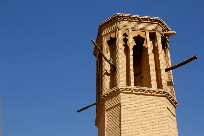 Close-up of a traditional wind tower architecture against a clear blue sky.
