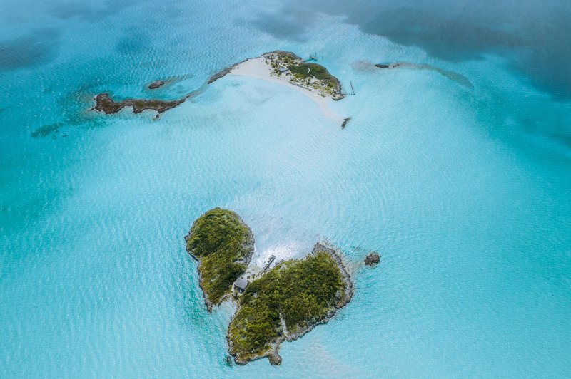 A breathtaking aerial view of lush green islands surrounded by vibrant turquoise ocean water.