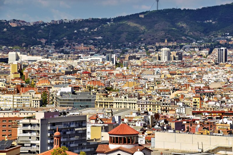 Aerial view of Barcelona's urban landscape with hills in the background showcasing architectural diversity.