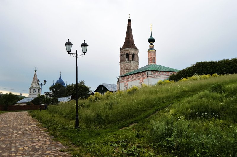 Charming view of a historic Russian church with towers and a cobblestone path.