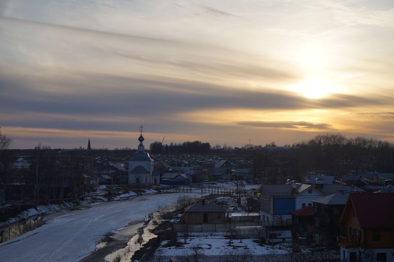 Captivating winter sunset view over the historic town of Suzdal, Russia, showcasing a charming church and snowy landscape.